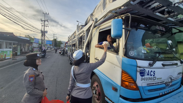 Polresta Banyuwangi Berbagi Mamiri Kepada Pengguna Jalan yang Terjebak Kepadatan Pelabuhan Ketapang